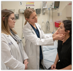 A Faculty Member Examines a Patient as a Medical Student Observes