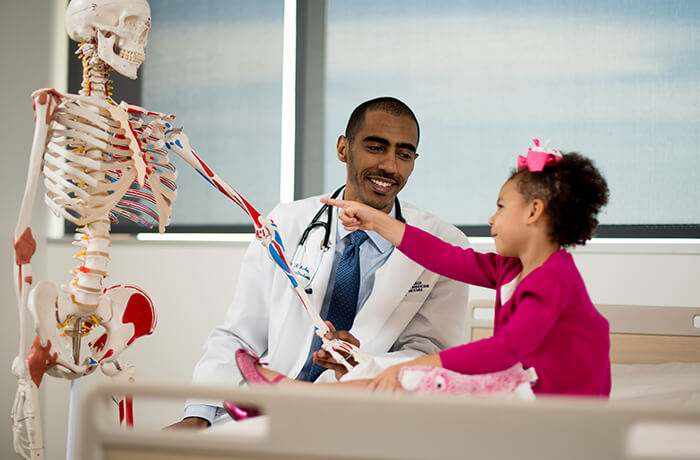 A Medical Student Shows a Skeleton to a Pediatric Patient