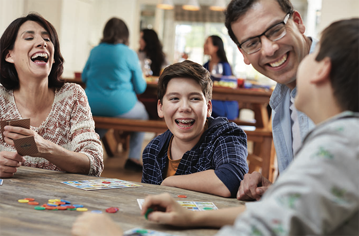 A Family Plays a Board Game at a Table