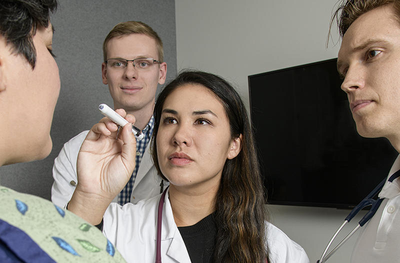Three medical students observe a patient