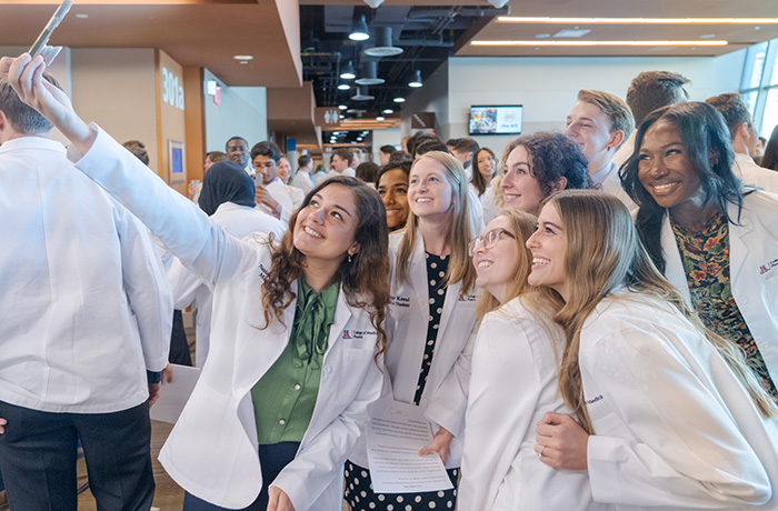 Class of 2027 medical students take a selfie at the White Coat Ceremony