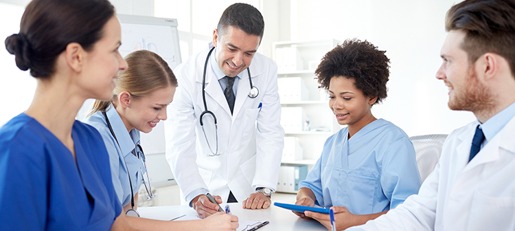 A group of physicians huddled at a table