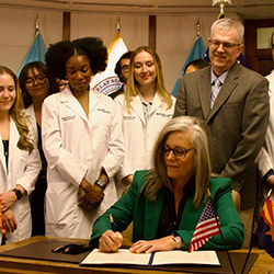 Arizona Governor Katie Hobbs signing a health care Executive Order with family medicine residents in August 2025. Arizona Governor Katie Hobbs signing a health care Executive Order with family medicine residents in August 2025.