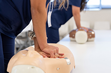 Two people performing CPR on mannequins