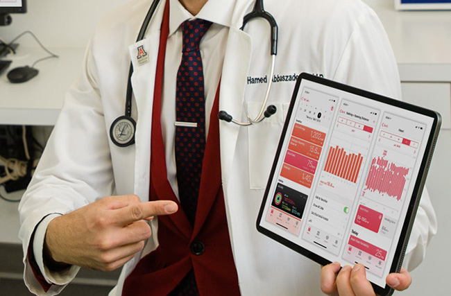 A doctor holding up vital statistics on an iPad