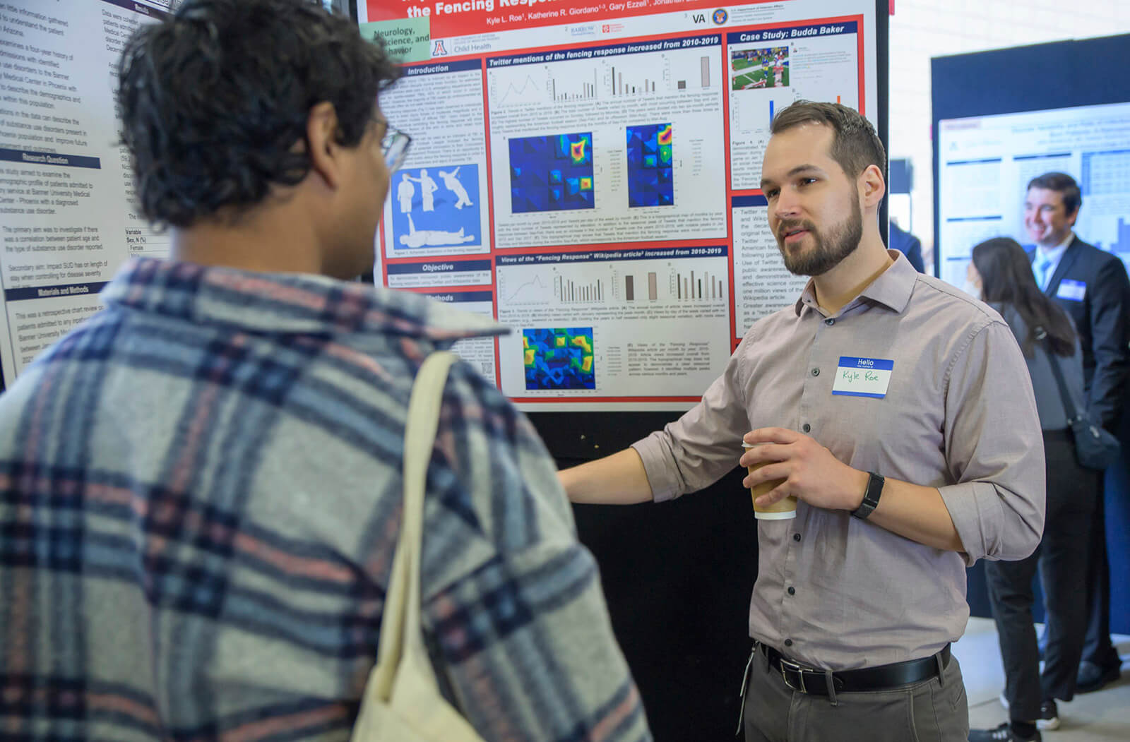 A student discusses his research project with an attendee