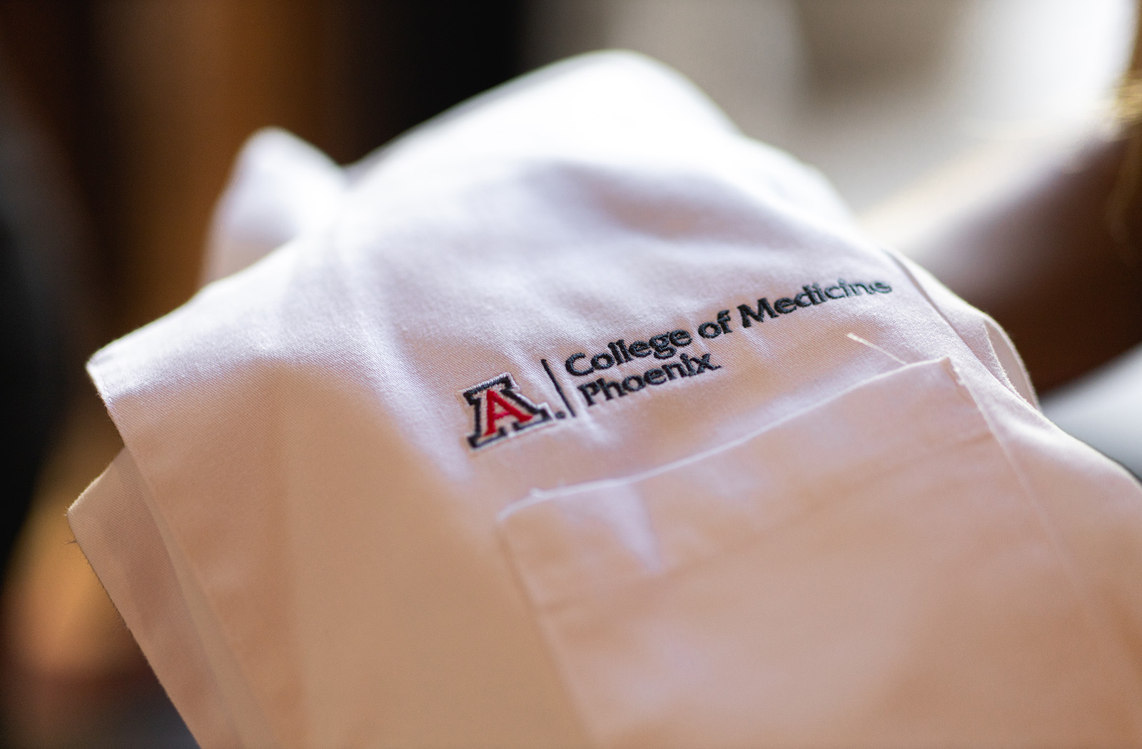 A white coat with the college's logo on it