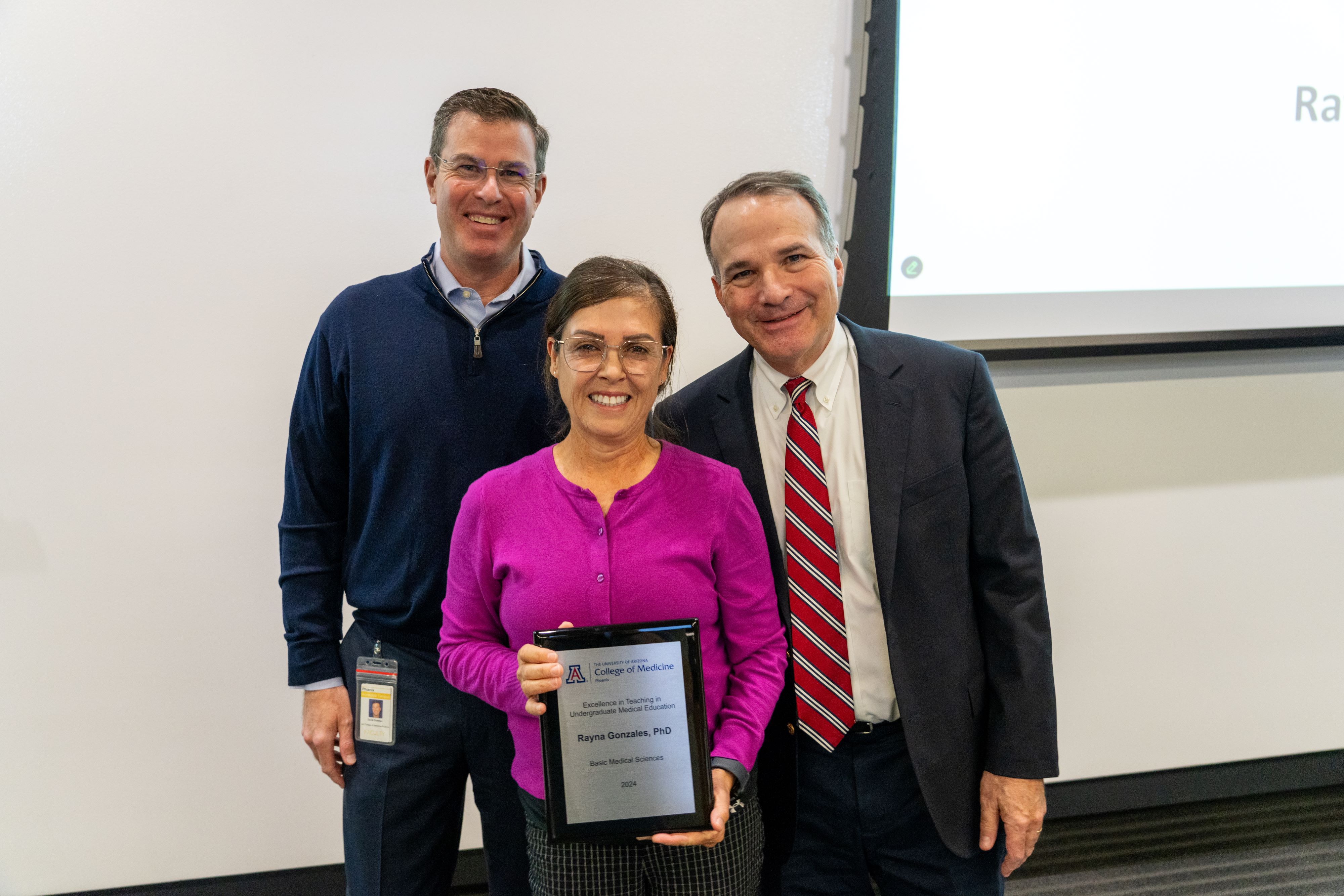 Rayna Gonzales, PhD poses with David Guttman, MD, and Dean Fredric Wondisford after receiving her award