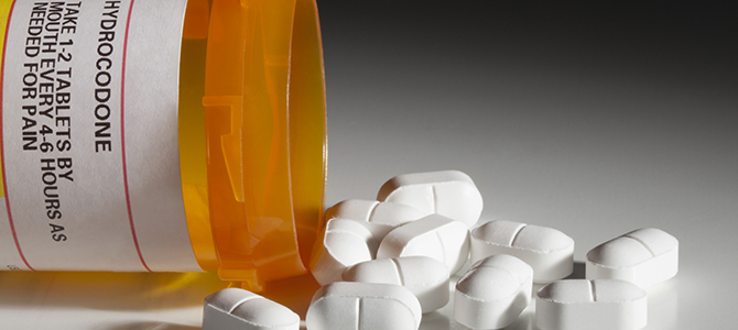 prescription bottle spilling pills on a counter 