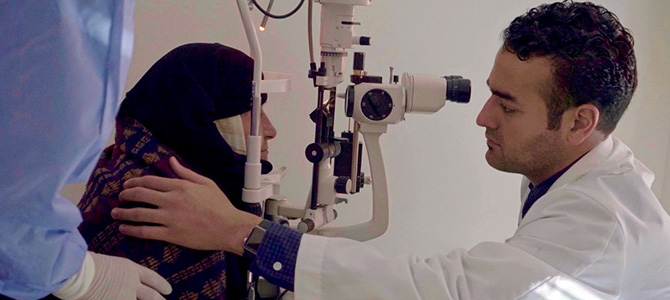 Dr. Behshad Performing an Eye Exam on a Patient