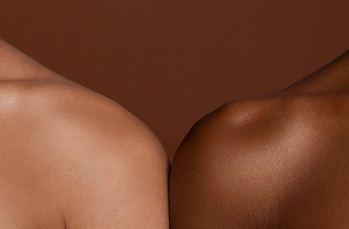 People with differing skin tones stand shoulder to shoulder