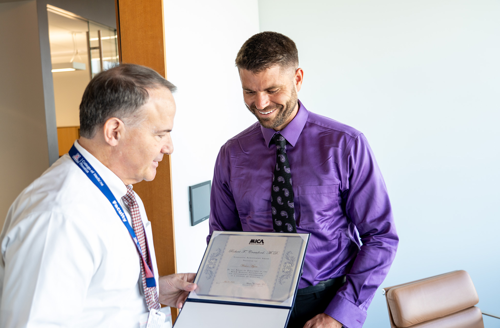 Dean Fred Wondisford, MD, MS, MBA, delivers the exciting news to fourth-year medical student Weston Myers