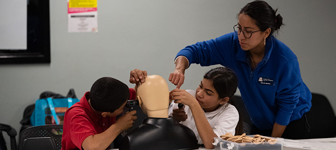 Students Examine the Ears of the College’s Simulation Mannequin