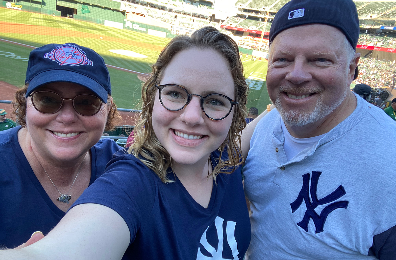 Annika Ozols with her parents at a baseball game