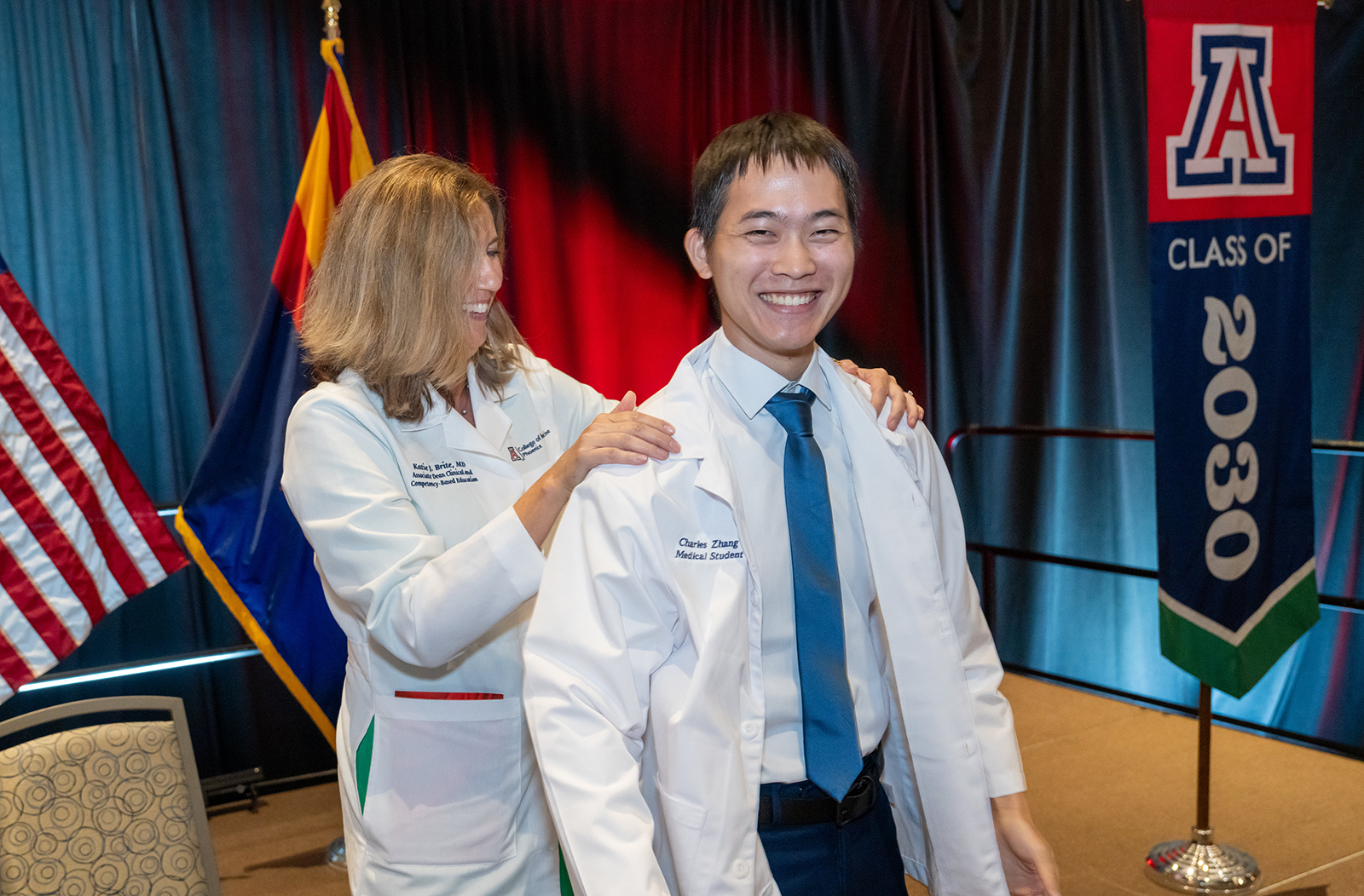 Katie Brite Hillis, MD, interim vice dean of Medical Education for the college's Yuma Regional Branch, coats Charles Zhang at the ceremony.