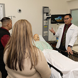 Abel de Castro, Class of 2023, showing attendees the technology in the college's Center for Simulation and Innovation