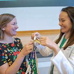 Claire Faulkner ties her ribbon with Stephanie Briney, DO