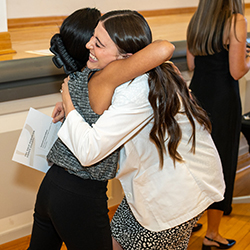Class of 2026 inductee Erika Yasuda hugs Class of 2027 inductee Susannah Cowley Rallison.