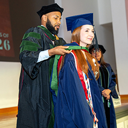 Nafis Shamsid-Deen, MD, director of the Pathway Scholars Program, stoles Sophia Justice. 