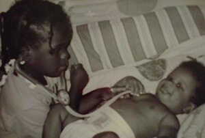 A young Moore plays "doctor" with her baby brother