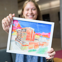 Nguyen proudly displays her painting of the Biomedical Sciences Partnership Building