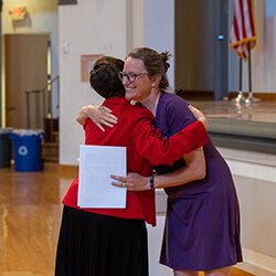 Dr. Hale embraces Dr. Nichols before delivering her remarks