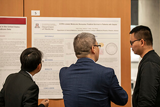 Symposium Attendees Discussing One of the Research Posters