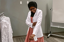 Fatouma Tall tries on her white coat