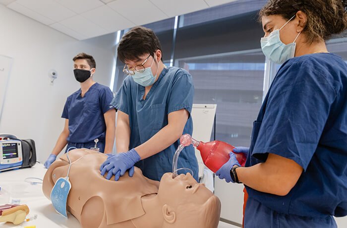 Three Medical Students Performing Sim Activities with Masks On