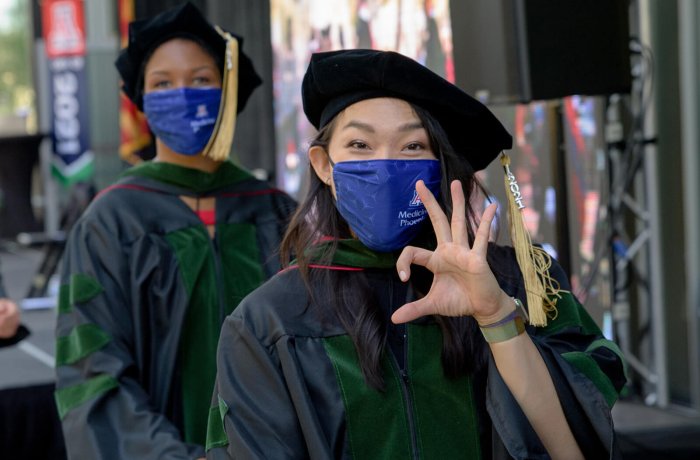 A Graduating Medical Student Flashes the Wildcat Hand Sign at Commencement