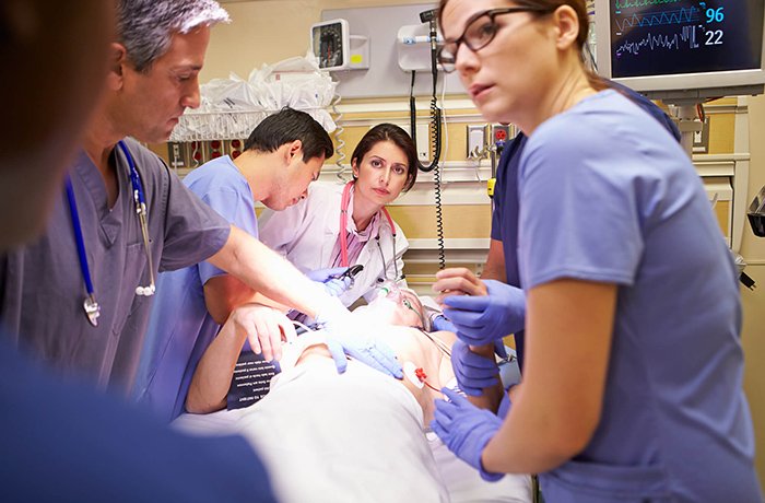 A team of doctors work on a patient in the ER