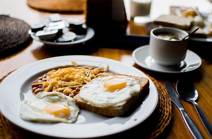 A breakfast platter with eggs, toast, beans and coffee