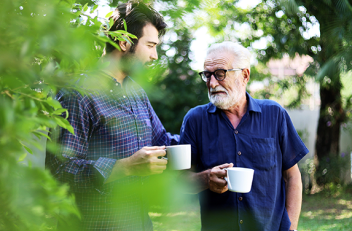 A young man and his father talk over coffee