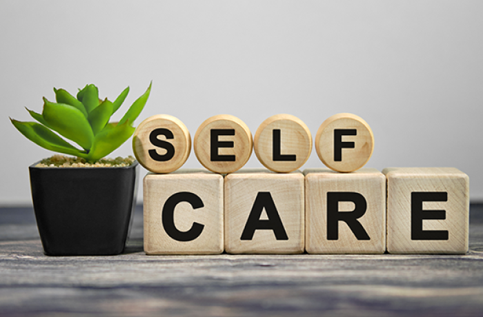 "Self Care" spelled in wood blocks