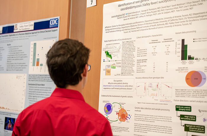 A Student Studies a Research Poster at a Conference