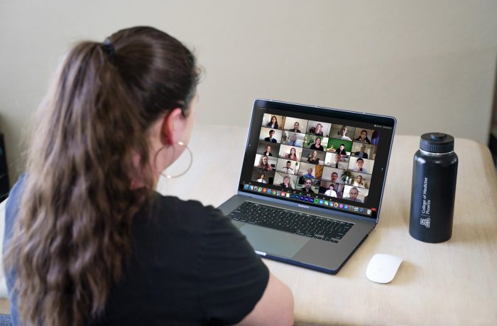 A Woman Attends a Zoom Meeting on Her Laptop