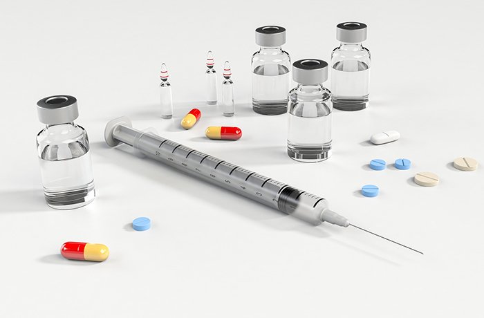 A syringe, pills and vials of insulin