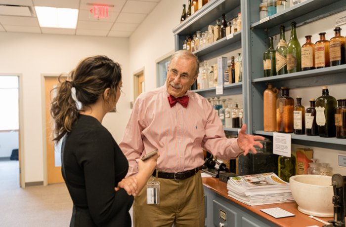 Robert Kravetz, MD, shows a student some of his antiques