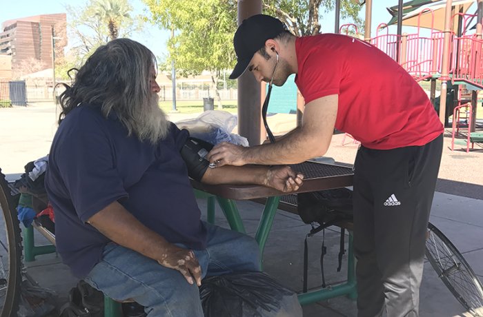 The Street Medicine Phoenix team administers care to a local homeless person