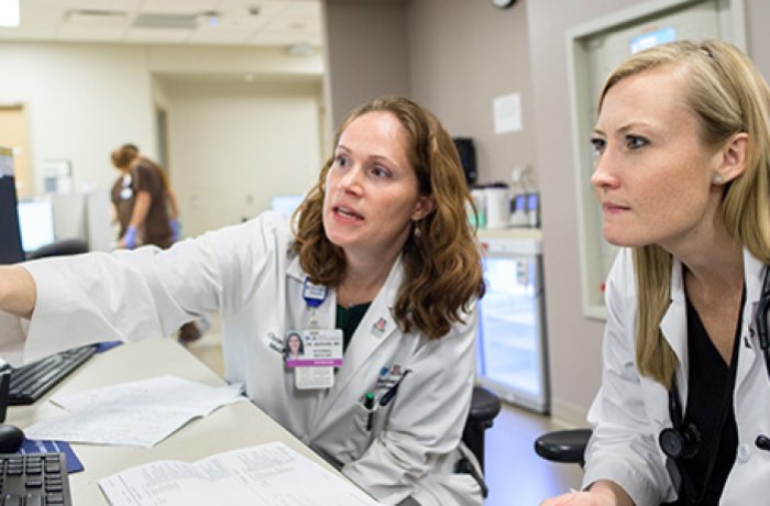 A physician consults with a resident in the clinical setting