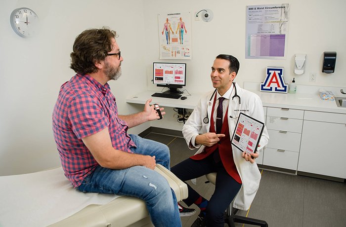 Dr. Abbaszadegan with a Patient Showing Them Their Health Stats