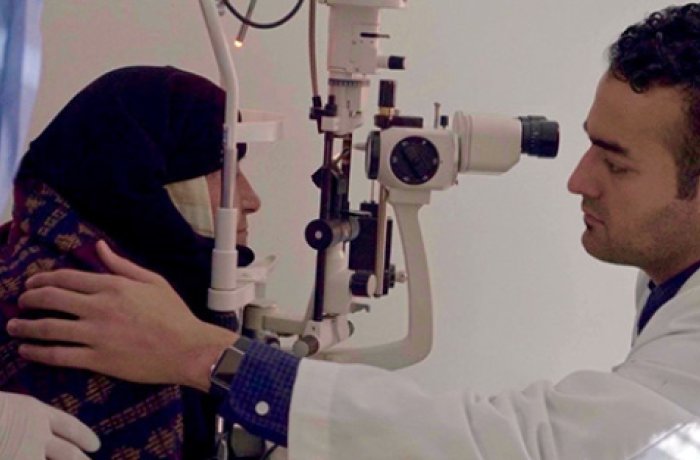 Dr. Behshad Performing an Eye Exam on a Patient