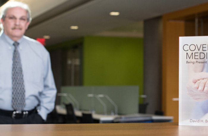 David Beyda, MD, Stands in the Background; His Book is in the Foreground