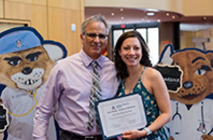 medical student poses for photo with their award