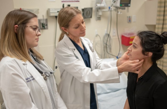 Physician with student examine a patient