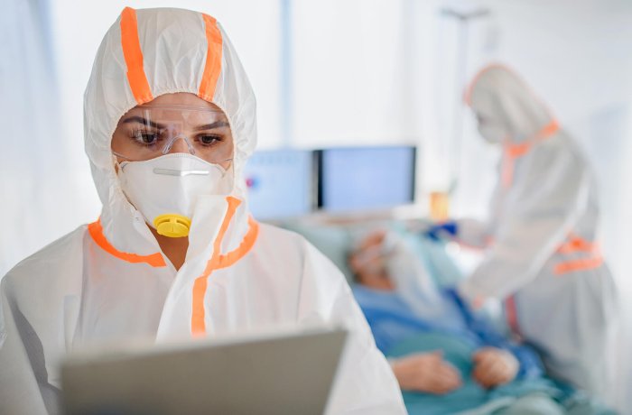 Nurses in Protective Gear Attend to a COVID-19 Patient in the Hospital Setting