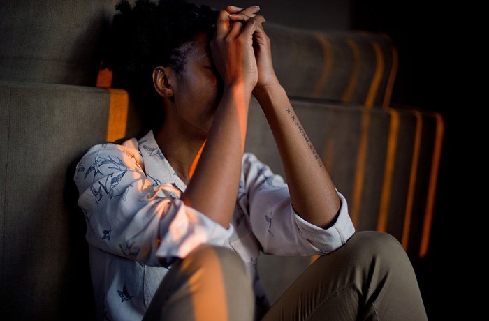 A young women sits with her head in her hands