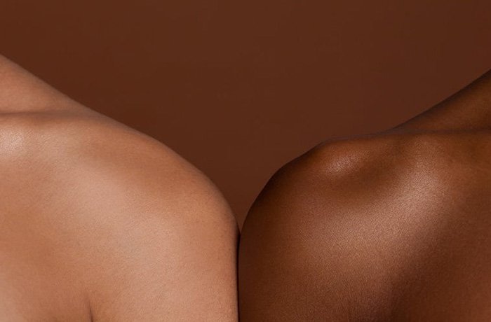 People with differing skin tones stand shoulder to shoulder