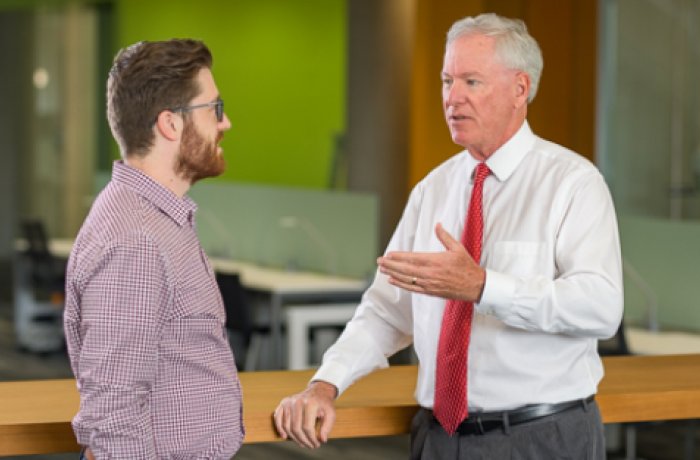 William Dolan, MD interacting with a student