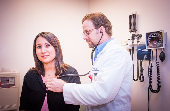 Ken Knox, MD, checking a patient's lungs